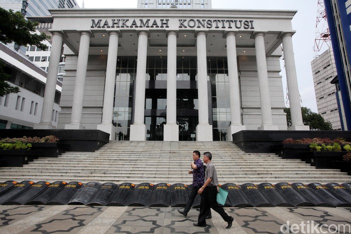 Sidang Sengkeda Hasil Pilkada di MK --- Mahkamah Konstitusi kembali menggelar sidang perkara sengketa hasil Pilkada di Gedung MK, Selasa (12/1/2016). Sidang yang terbagi dalam 3 panel tersebut mengagendakan jawaban termohon dan pihak terkait. Banyaknya jumlah perkara dan pendukung masing-masing calon membuat MK membatasi pengunjung sidang. Bagi yang tidak bisa masuk ruang sidang, disediakan 3 layar lebar di sebuah tenda di luar gedung MK. (Ari Saputra/detikcom)