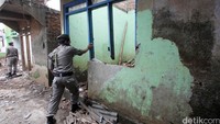 Petugas Satpol PP membongkar salah satu rumah.