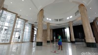 Seorang pekerja membersihkan lantai masjid.