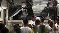 Demonstran berorasi di bawah guyuran hujan.