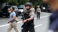 Polisi dengan senjata laras panjang, wara wiri di sekitar lokasi ledakan.