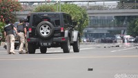 Anggota kepolisian berlindung di balik SUV Jeep Wrangler saat mencoba merangsek masuk ke dalam Gedung Cakrawala di jalan Thamrin, Jakarta Pusat.  Foto: Lamhot Aritonang