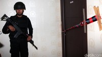 Penggeledahan dilakukan dengan pengawalan polisi.
