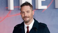 Sementara bintang film Mad Max: Fury Road itu juga terlihat gagah dengan kemeja putih, dasi merah dan coat biru dongker. John Phillips/Getty Images/detikFoto.