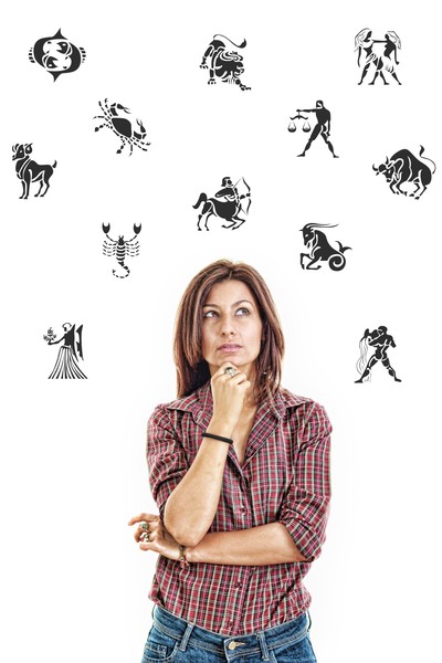 woman surrounded with zodiac signs thoughtfully looking up with