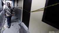 Seorang warga melintas di depan rumah yang telah dipasangi garis polisi tersebut.