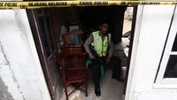 Seorang polisi bersenjata laras panjang berjaga di rumah yang dijadikan sebagai tempat untuk pesta narkoba tersebut.