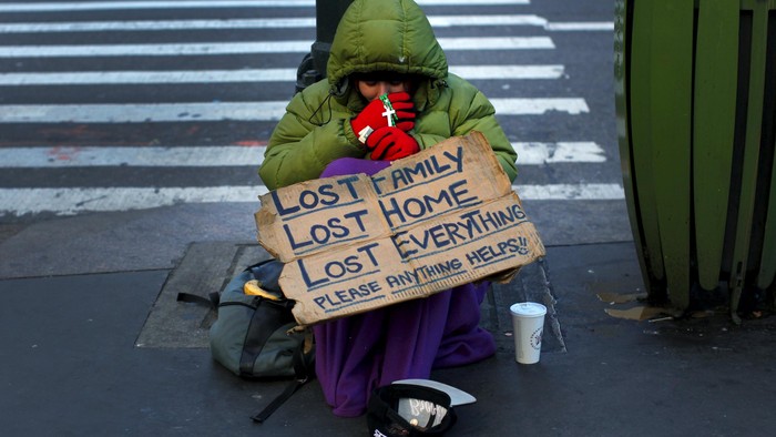 A homeless woman sits bundled against the cold as she begs for handouts on East 42nd Street in the Manhattan borough of New York City, January 4, 2016. New York Governor Andrew Cuomo signed an executive order on Sunday requiring local officials throughout the state to force the homeless into shelters when temperatures dip below freezing and vowed to defend the edict if challenged in court. REUTERS/Mike Segar