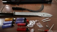 Polisi mengamankan barang bukti senjata tajam.