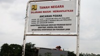 Sebuah plang bertuliskan Tanah Negara terpampang di lokasi proyek.