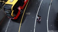Bus TransJakarta melintas di antara pengunjung Car Free Day.