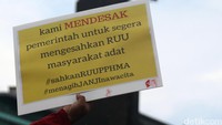 Salah satu poster yang dibawa bertuliskan kami mendesak pemerintah untuk segera mengesahkan RUU masyarakat adat.
