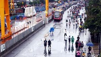 Sebagian warga menikmati Car Free Day menggunakan payung dan jas hujan.