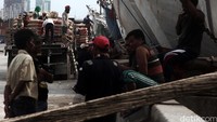 Sejumlah pekerja menurukan semen dari atas kapal.