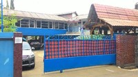 Tak jauh dari gang, sekitar 100 meter, ada bangunan berwarna biru dengan pagar berwarna biru yang ditutupi kain kotak-kotak merah hitam. Nah, itulah markas Slank (Shafa/detikTravel)