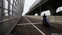 Pekerja melintas di tol akses Pelabuhan Tanjung Priok yang masih dalam tahap pembangunan.