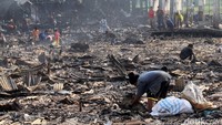 Warga tampak mengais di sisa-sisa kebakaran Kampung Bandan.