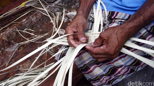 Seorang perajin Topi Tiilangga merajut daun lontar untuk dasar pembuatan topi yang sangat khas dari Nusa Tenggara Timur, Jumat (29/1/2016).