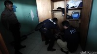 Petugas memeriksa lemari salah satu penghuni kos.
