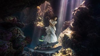 Proyek foto terbaru Wong ini mengambil lokasi di Pulau Fiji, Pasifik Selatan. Jika di Bali menggunakan kapal karam, kali ini ia menggunakan ikan hiu untuk menemani sang model! Foto: Benjamin Von Wong