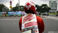 Mereka berbaris di pinggir jalan sambil membentangkan spanduk.