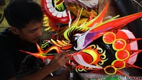 Pengrajin menyelesaikan pembuatan kepala liong.