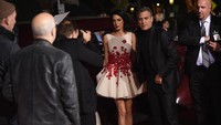 Tangan Amal terlihat tak mau lepas dari genggaman sang suami. Kevin Winter/Getty Images/detikFoto.