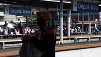 Calon penumpang menunggu kedatangan kereta.
