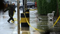 Penjinak bom hujan-hujanan untuk memeriksa kardus mencurigakan di depan Wisma Nusantara.