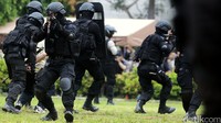 Dengan senjata api laras panjang dan perlengkapan keselamatan seperti body vest dan helm, tim Gegana berusaha melumpuhkan teroris yang bersembunyi.