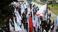 Buruh membawa atribut aksi, seperti bendera.