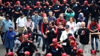 Para WNA itu berjalan di antara ribuan buruh.