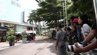 Warga dan para wartawan menyaksikan proses rekontruksi dari luar gedung.