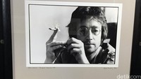 John nampak mengenakan kacamata dengan frame bulat yang jadi ciri khasnya.