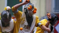 Selama ikutan festival ini, turis akan mengenakan masker khusus agar jeruk dan sarinya tidak terkena langsung ke wajah (Stefano Rellandini/Reuters)