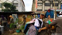 Petugas ikut mengevakuasi barang-barang milik warga.