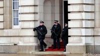 Polisi bersenjata lengkap menjaga salah satu pintu masuk istana.