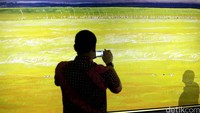 Seorang pengunjung mengabadikan salah satu lukisan karya Srihadi Soedarsono.