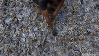 Seorang pekerja menggulung kulit ular yang telah mengering.