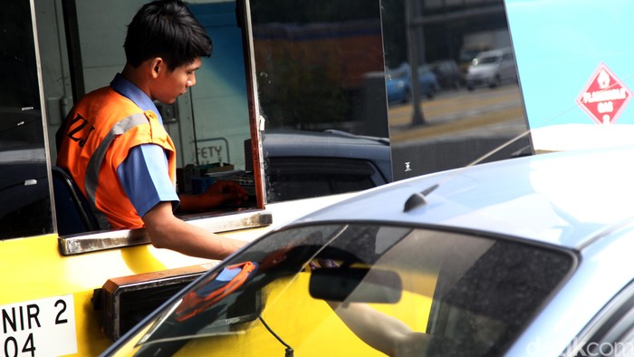 Petugas melalukan proses pengaturan pembayaran tol di Pintu Gerbang Tol Cikunir 2, Bekasi, Jawa Barat, Selasa (16/2/2016). Setelah terjadinya atap rubuh pada minggu kemarin tampak suasana gerbang tol berjalan normal meski atap rubuh masih terlihat. Dibagian atap yang rubuh disanggah dengan besi berukuran besar agar bisa dilewati kendaraan. Agung Pambudhy/Detikcom.
