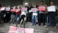 Demonstran membentangkan poster menolak revisi UU KPK.