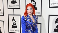 Ia memadukan busana biru nyentriknya dengan heels merah supertinggi. Jason Merritt/Getty Images for NARAS/detikFoto.