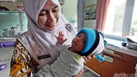 Perawat menggendong bayi yang ditemukan di rumah warga di RT 04/06 Kelurahan Sawangan Baru, Kecamatan Sawangan.