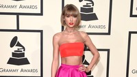 Pelantun Wildest Dreams itu dibalut busana berwarna neon, kemben merah menyala dan rok shocking pink dengan belahan tinggi sepaha yang memamerkan kaki jenjangnya. Jason Merritt/Getty Images for NARAS/detikFoto.