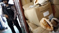 Polisi bersenjata laras panjang menjaga cangkang kerang langka yang berhasil disita.