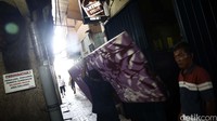 Para penghuni bergegas dari Kalijodo dengan barang-barang bawaan.