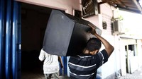 Para penghuni meninggalkan Kalijodo sambil memanggul barang bawaan.