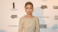 Model berusia 20 tahun itu memilih dress mini bernuansa emas dipadu sepatu bot tinggi berwarna senada. Gustavo Caballero/Getty Images/detikFoto.