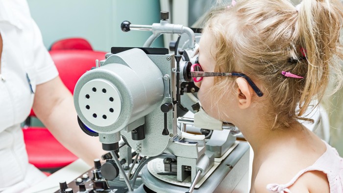 Optometrist with patient, giving an eye examination