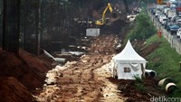 Alat berat melakukan pengerukan.